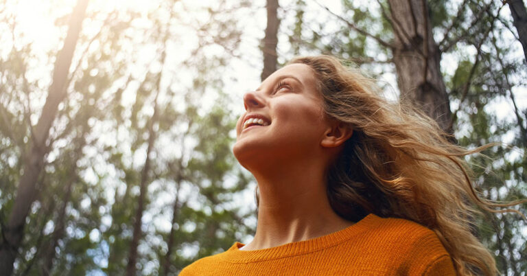 woman with sunshine on face in nature