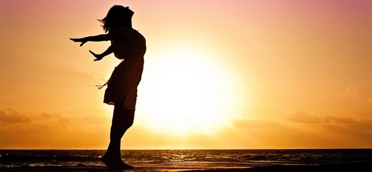 Woman standing on the beach in the sunset