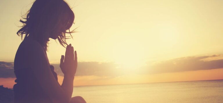 Woman praying on the beach