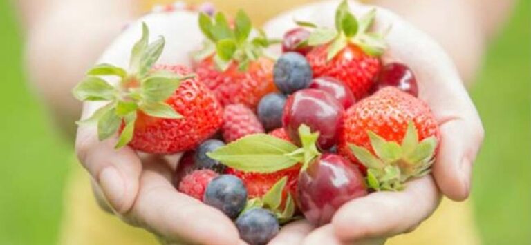 A photo of two hands holding fruit