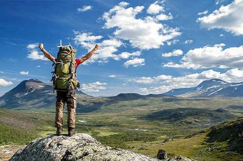 Man celebrating on top of a mountain
