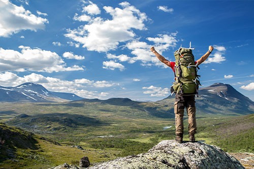 Man celebrating on top of a mountain