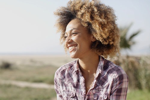 Photo of a woman smiling outside.