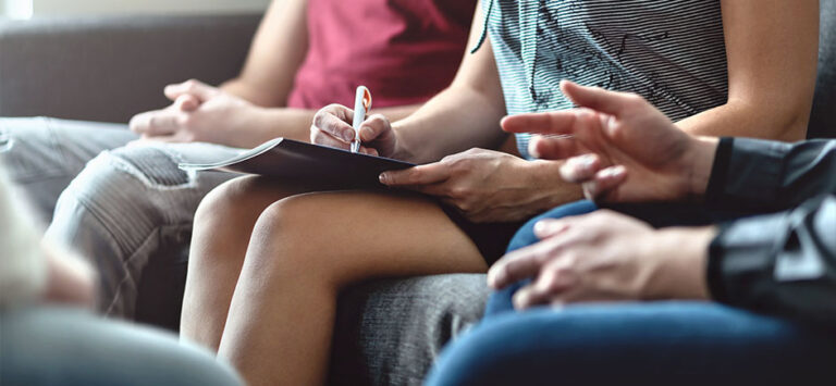 woman writing at NA meeting